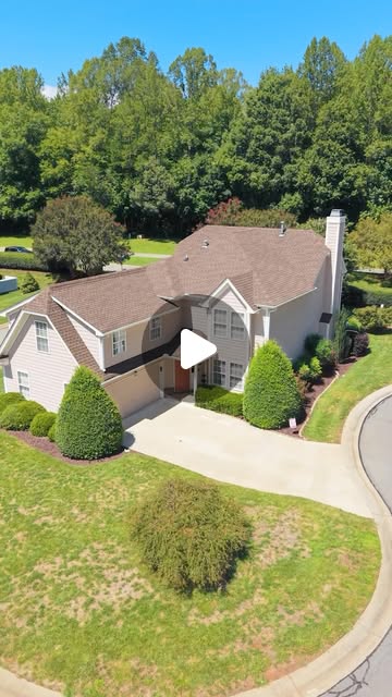Aerial view of a two-story home surrounded by trees